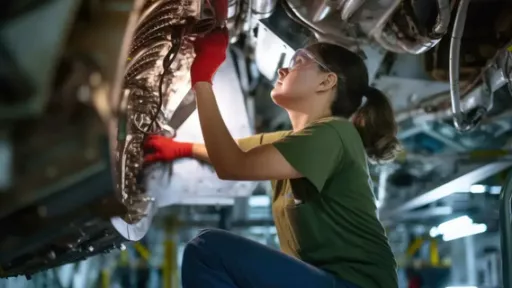 Jeune femme apprentie en train de r&eacute;parer une voiture