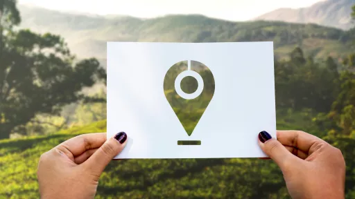Feuille blanche tenue par deux mains de femmes, devant un paysage de campagne. Au centre de la feuille blanche, en pochoir, un picto &laquo; position &raquo; qui laisse voir le paysage.