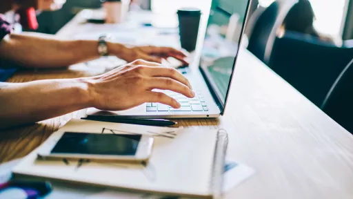 Cropped view of hands typing text on keyboard of modern laptop computer in search useful information on internet websites.Courses for IT professionals at digital netbook.Installing app on device