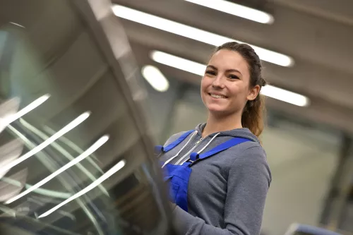 Portrait of apprentice standing in mechanics workshop